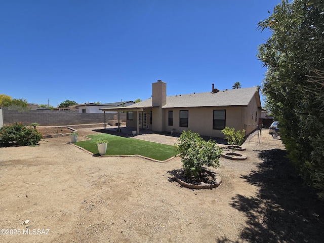 rear view of property featuring a patio area, a lawn, a chimney, fence private yard, and roof with shingles