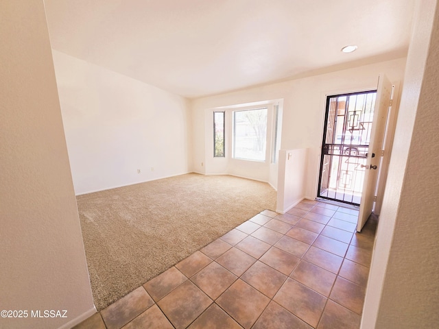 tiled empty room featuring carpet floors