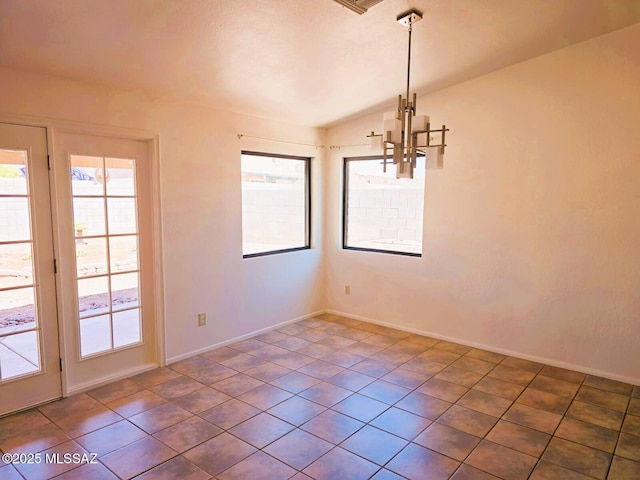 unfurnished dining area featuring lofted ceiling, tile patterned floors, baseboards, and a chandelier