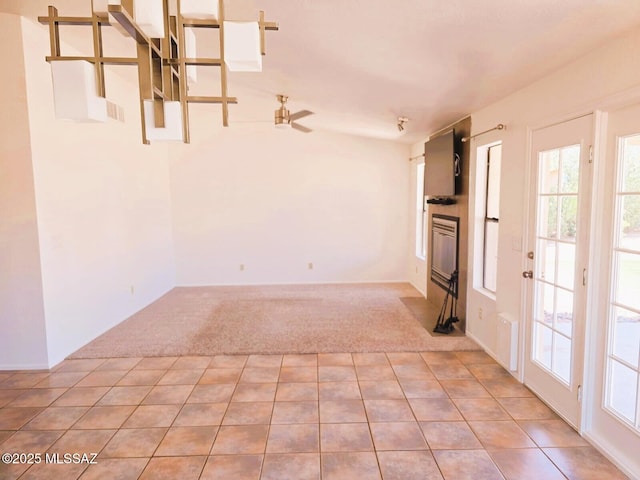 carpeted spare room with tile patterned floors and visible vents