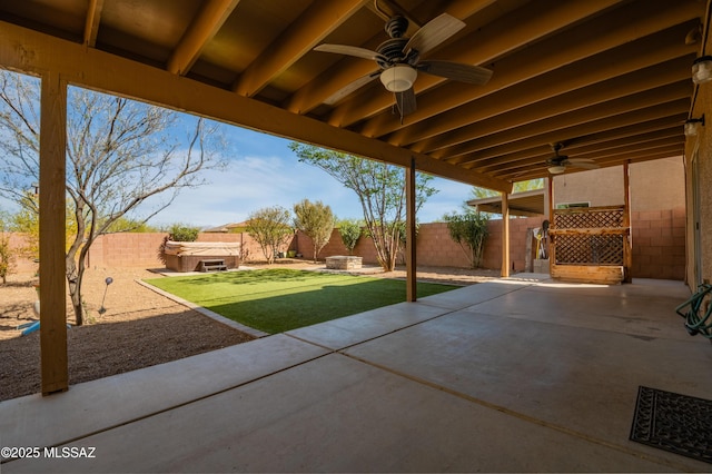 view of patio / terrace with ceiling fan, a fenced backyard, and a hot tub