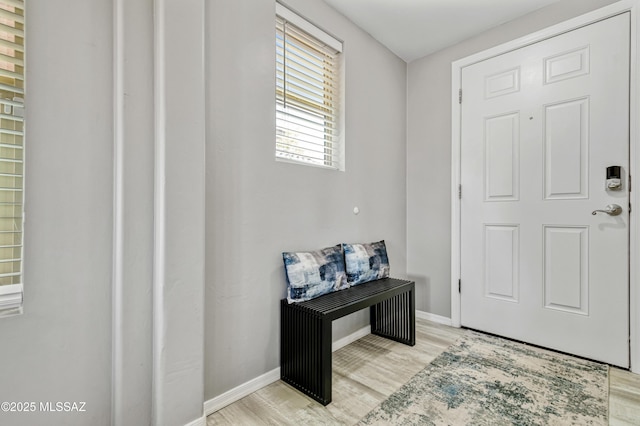 foyer entrance featuring baseboards and light wood-style flooring