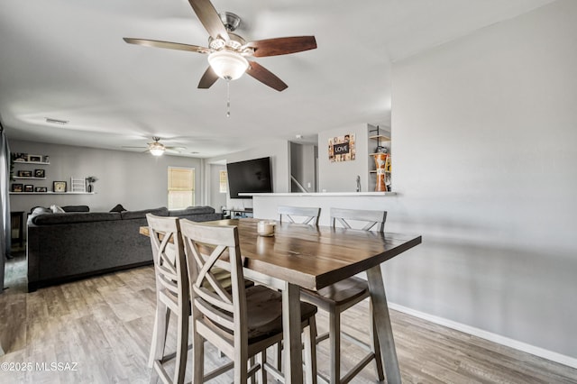 dining area featuring ceiling fan, baseboards, visible vents, and light wood finished floors