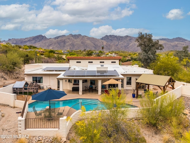 4644 N Avenida Del Cazador, Tucson, AZ 85718 - back of property featuring outdoor dining space, a fenced backyard, roof mounted solar panels, and a mountain view