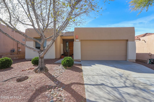adobe home featuring a garage, stucco siding, driveway, and a tile roof