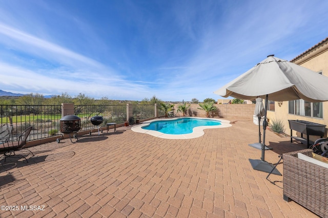 view of swimming pool featuring a fenced in pool, a fenced backyard, a mountain view, and a patio