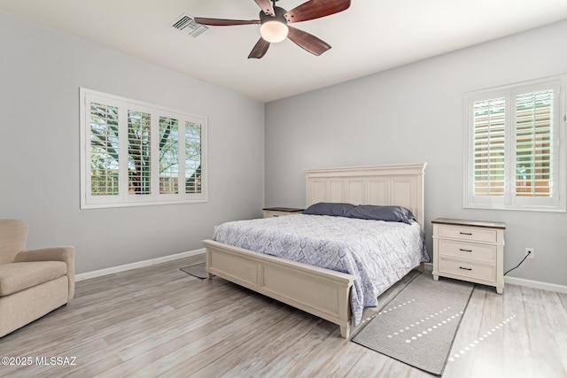 bedroom with baseboards, visible vents, ceiling fan, and light wood finished floors