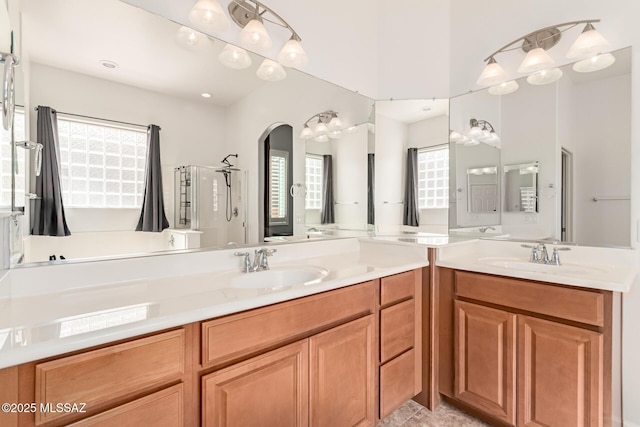 bathroom featuring a shower, vanity, and a healthy amount of sunlight