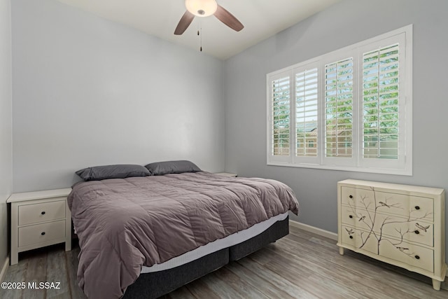 bedroom with baseboards, wood finished floors, and ceiling fan