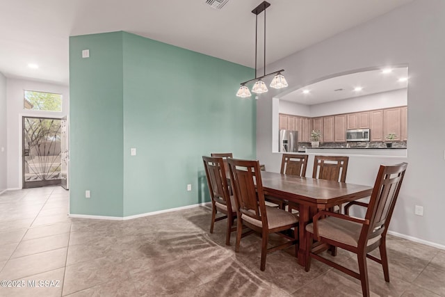 dining area featuring light tile patterned floors, visible vents, arched walkways, baseboards, and recessed lighting