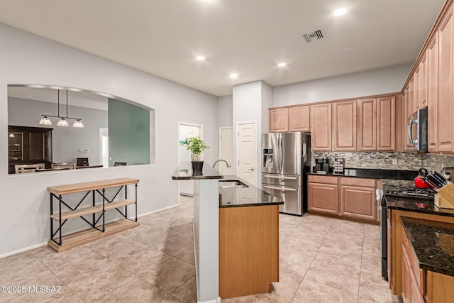 kitchen with a sink, stainless steel appliances, visible vents, backsplash, and arched walkways