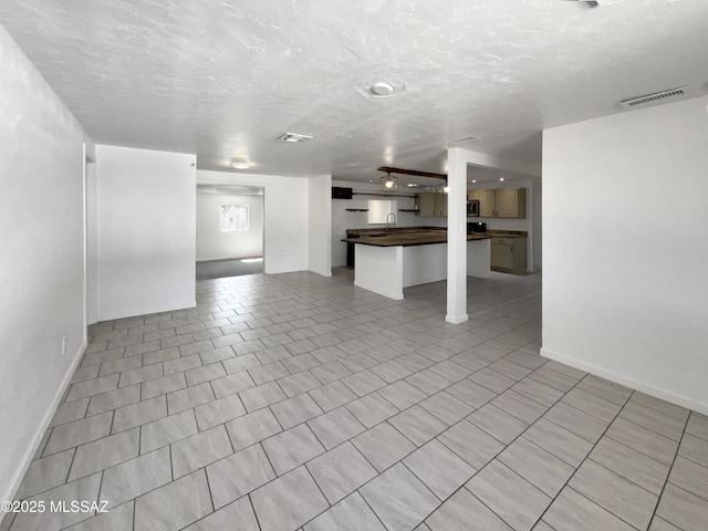 6760 S Calle Gavilan, Tucson, AZ 85746 - unfurnished living room with baseboards, visible vents, and a textured ceiling