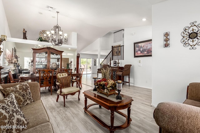 3825 W Perseus St, Tucson, AZ 85742 - living room with visible vents, an inviting chandelier, light wood-style floors, stairway, and high vaulted ceiling