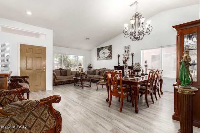 3825 W Perseus St, Tucson, AZ 85742 - dining space with lofted ceiling, visible vents, light wood-style flooring, and a notable chandelier
