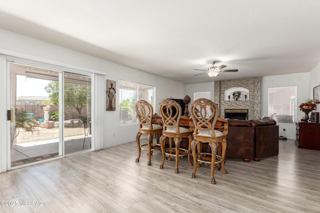 3825 W Perseus St, Tucson, AZ 85742 - dining area with a stone fireplace, light wood-style floors, and ceiling fan