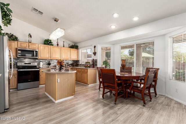 3825 W Perseus St, Tucson, AZ 85742 - kitchen featuring light wood finished floors, a center island, a sink, visible vents, and appliances with stainless steel finishes