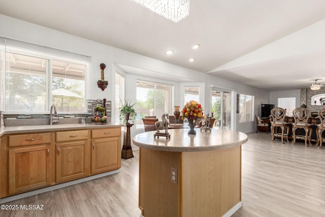 3825 W Perseus St, Tucson, AZ 85742 - kitchen with light wood finished floors, open floor plan, an inviting chandelier, lofted ceiling, and a kitchen island