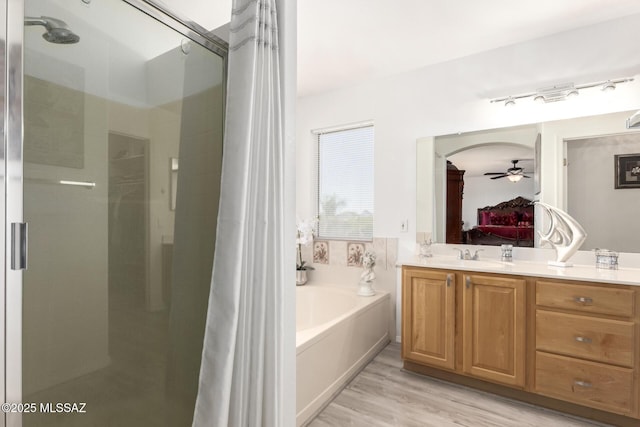 3825 W Perseus St, Tucson, AZ 85742 - bathroom with a garden tub, a ceiling fan, a stall shower, connected bathroom, and vanity