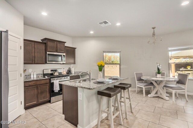 17949 S Whispering Glen Path, Sahuarita, AZ 85629 - kitchen featuring appliances with stainless steel finishes, a sink, light stone countertops, dark brown cabinets, and recessed lighting