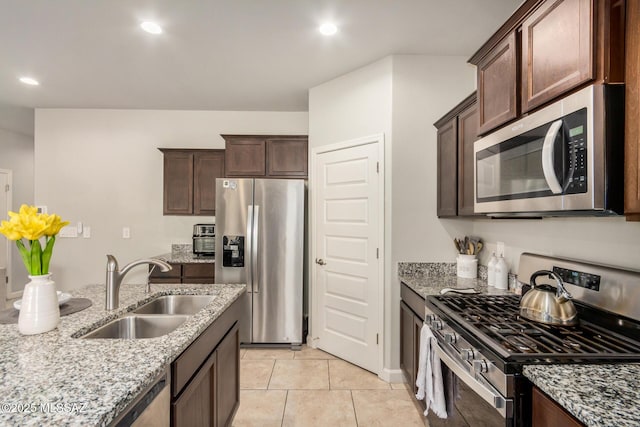 17949 S Whispering Glen Path, Sahuarita, AZ 85629 - kitchen with stainless steel appliances, a sink, light stone countertops, dark brown cabinets, and recessed lighting
