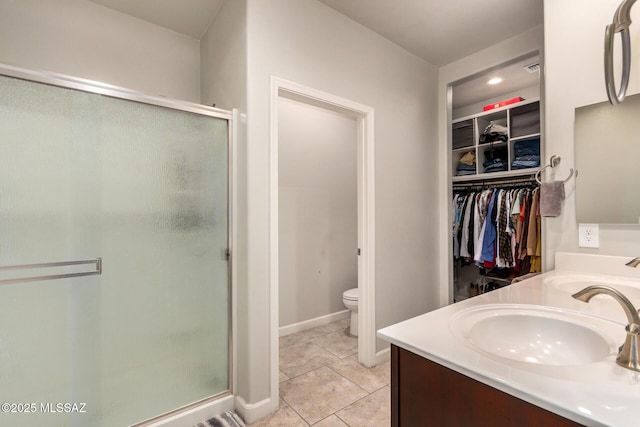 17949 S Whispering Glen Path, Sahuarita, AZ 85629 - full bath featuring a stall shower, toilet, double vanity, a spacious closet, and tile patterned flooring