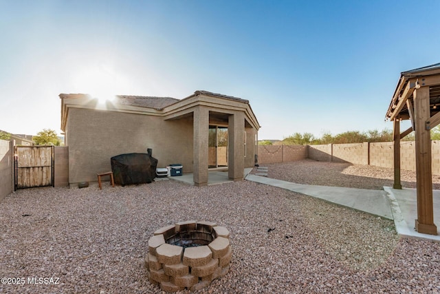 17949 S Whispering Glen Path, Sahuarita, AZ 85629 - back of house with an outdoor fire pit, stucco siding, a fenced backyard, a gate, and a patio