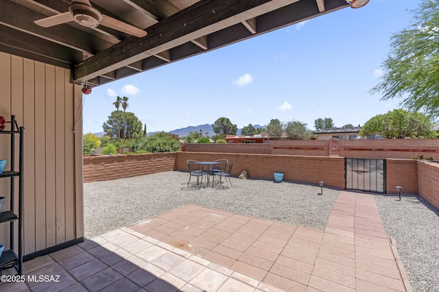 1376 S Desert Meadows Cir, Green Valley, AZ 85614 - view of patio / terrace featuring ceiling fan, a fenced backyard, a mountain view, and a gate
