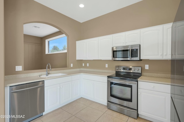 38876 S Serenity Ln, Tucson, AZ 85739 - kitchen with a sink, arched walkways, stainless steel appliances, white cabinetry, and visible vents