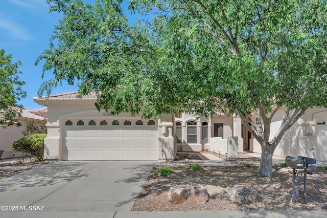 38876 S Serenity Ln, Tucson, AZ 85739 - view of property hidden behind natural elements with a garage, stucco siding, and concrete driveway
