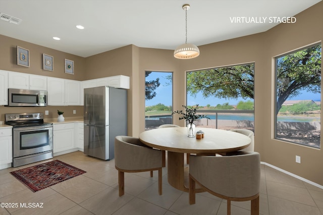 38876 S Serenity Ln, Tucson, AZ 85739 - kitchen featuring light tile patterned floors, stainless steel appliances, light countertops, white cabinetry, and visible vents