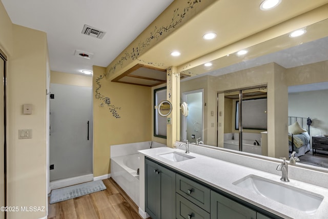 7361 E Riverbank Loop, Tucson, AZ 85715 - bathroom featuring wood finished floors, visible vents, a bath, and a sink