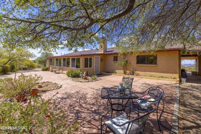280 W Oak Hills Dr, Oracle, AZ 85623 - back of house featuring brick siding, a patio area, a chimney, and a sunroom