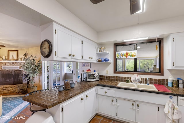 280 W Oak Hills Dr, Oracle, AZ 85623 - kitchen with a peninsula, white cabinets, a sink, dark tile patterned floors, and tile counters