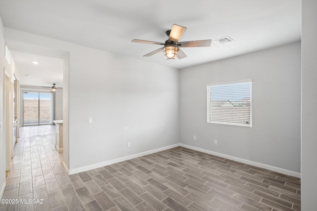 empty room featuring wood finished floors, baseboards, a ceiling fan, and visible vents