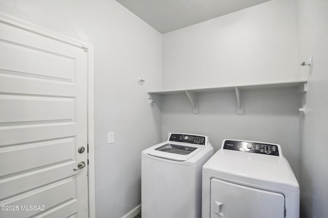 clothes washing area featuring washing machine and clothes dryer and laundry area