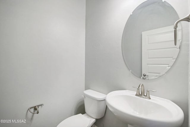 half bath featuring a sink and toilet