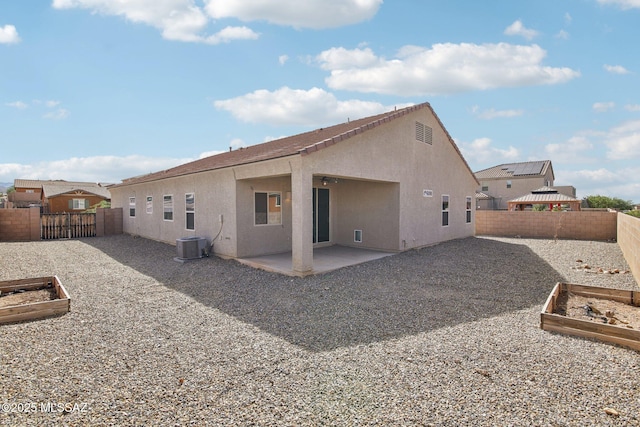back of property featuring a patio area, a vegetable garden, central AC, and stucco siding