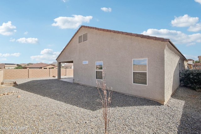 rear view of property featuring a patio area, a fenced backyard, and stucco siding