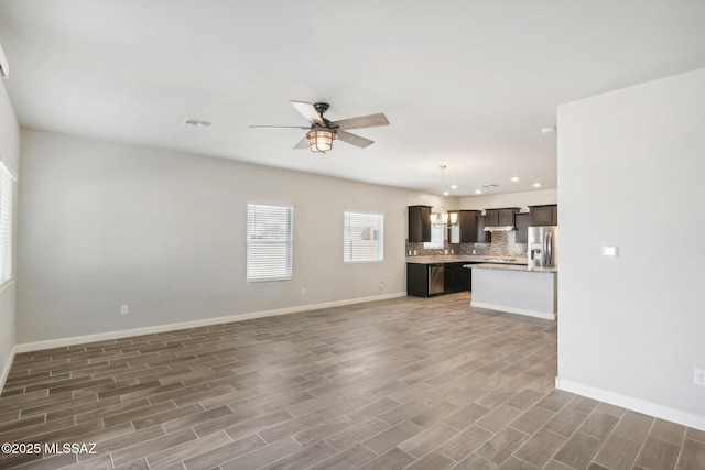 unfurnished living room featuring ceiling fan, baseboards, wood finished floors, and recessed lighting