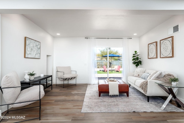 living room featuring recessed lighting, wood finished floors, visible vents, and baseboards