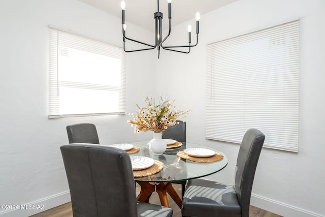 dining area featuring an inviting chandelier, wood finished floors, and baseboards