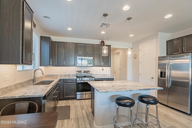 21372 E Charmaine Rd, Red Rock, AZ 85145 - kitchen with a sink, appliances with stainless steel finishes, visible vents, light stone countertops, and light wood finished floors