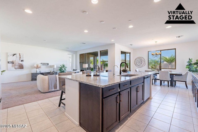 10965 N Cormac Ave, Tucson, AZ 85742 - kitchen with stainless steel dishwasher, light tile patterned flooring, a sink, light colored carpet, and light stone countertops