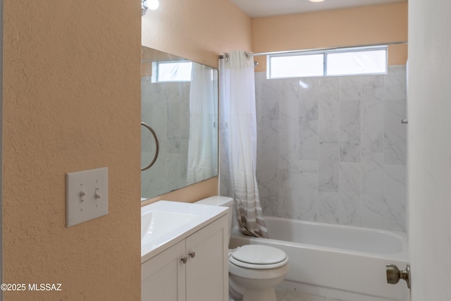 full bath with a textured wall, toilet, vanity, and plenty of natural light