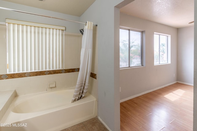 bathroom with shower / bath combination with curtain and baseboards