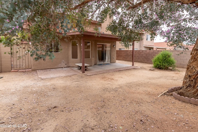 back of property with a patio, stucco siding, and fence