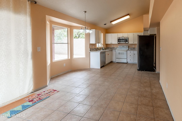 kitchen featuring stainless steel appliances, a sink, vaulted ceiling, a notable chandelier, and white cabinetry