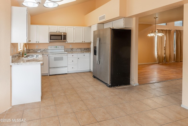 kitchen with a sink, light tile patterned floors, stainless steel appliances, a notable chandelier, and visible vents