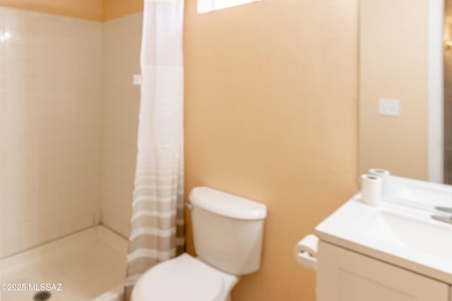bathroom with a shower stall, toilet, and vanity