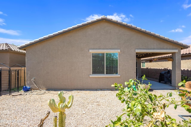 6515 E Vuelta Tierra Blanca, Tucson, AZ 85756 - view of side of home featuring a patio area, stucco siding, and a tiled roof